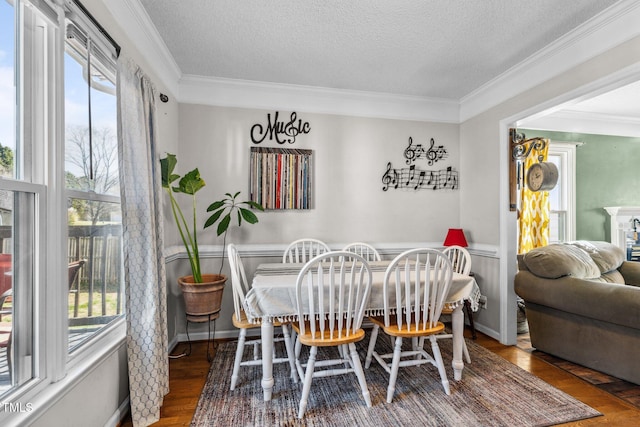 dining area with a textured ceiling, wood finished floors, and crown molding