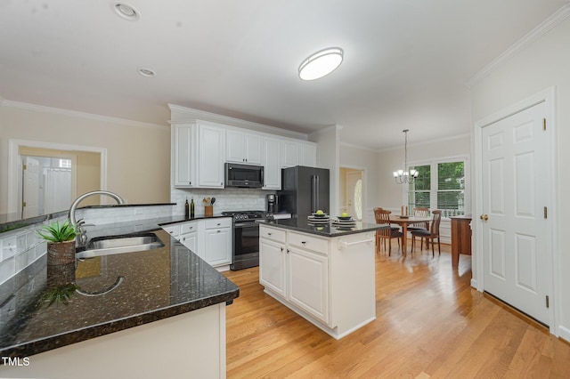 1208 Dunn Creek Xing, Wake Forest, NC 27587 - kitchen featuring stainless steel appliances, a sink, a chandelier, tasteful backsplash, and ornamental molding