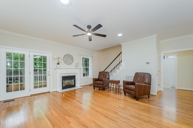 1208 Dunn Creek Xing, Wake Forest, NC 27587 - living area with light wood-style flooring, a premium fireplace, crown molding, ceiling fan, and stairway