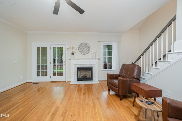 1208 Dunn Creek Xing, Wake Forest, NC 27587 - living area with healthy amount of natural light, ceiling fan, light wood-style floors, crown molding, and a high end fireplace