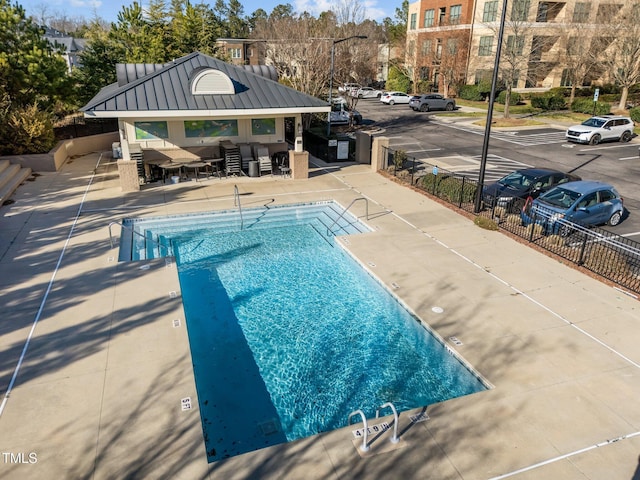 community pool featuring a patio and fence