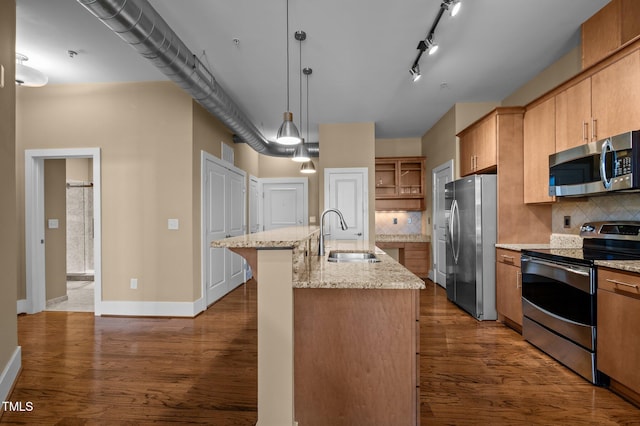 kitchen with dark wood-style floors, appliances with stainless steel finishes, light stone countertops, open shelves, and a sink