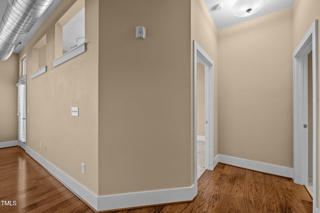 hallway featuring baseboards and wood finished floors