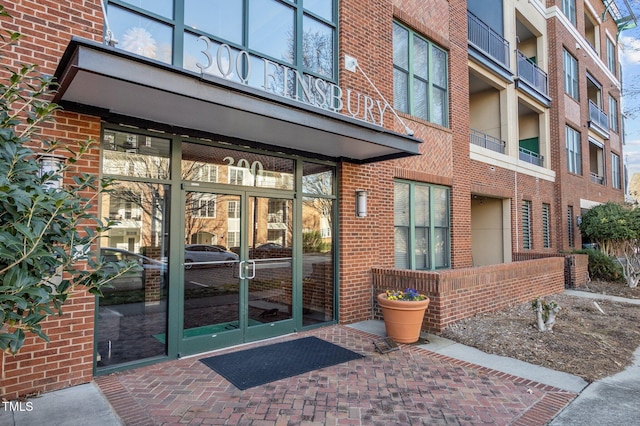 view of exterior entry featuring brick siding