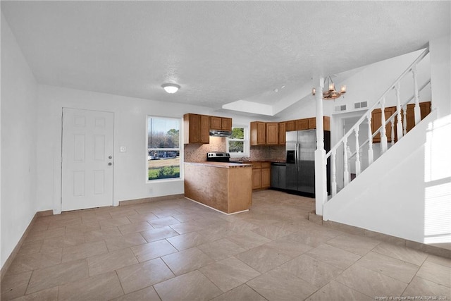 173 Style Dr, Parkton, NC 28371 - kitchen with a peninsula, stainless steel appliances, decorative backsplash, under cabinet range hood, and brown cabinets