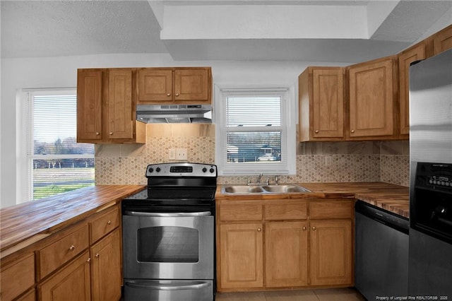 173 Style Dr, Parkton, NC 28371 - kitchen with wood counters, under cabinet range hood, appliances with stainless steel finishes, and a sink