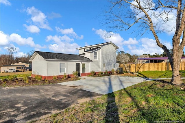 173 Style Dr, Parkton, NC 28371 - rear view of property with a yard, metal roof, driveway, and fence