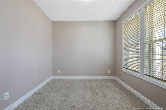 unfurnished room with carpet and baseboards