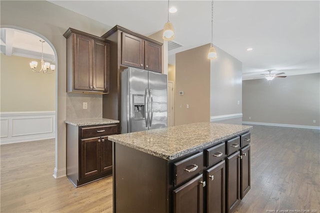 kitchen featuring arched walkways, ceiling fan, light wood-style floors, dark brown cabinets, and stainless steel refrigerator with ice dispenser