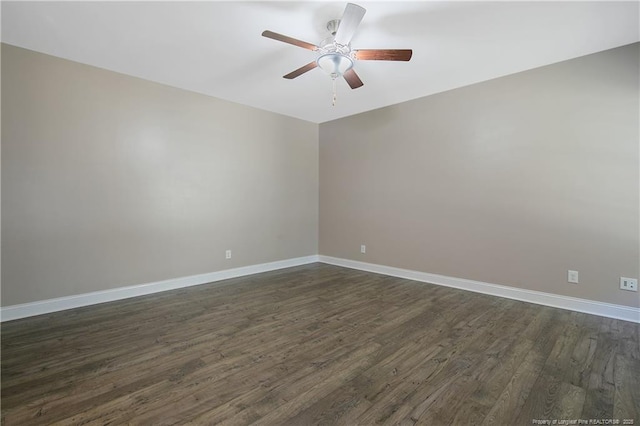 spare room featuring ceiling fan, dark wood finished floors, and baseboards