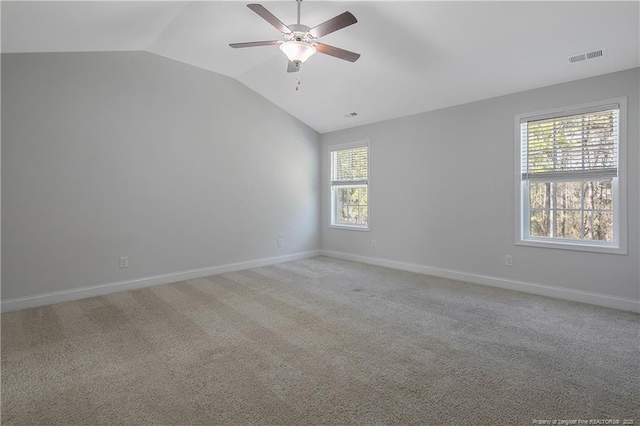 unfurnished room with vaulted ceiling, baseboards, visible vents, and light colored carpet