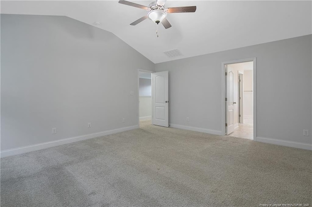 unfurnished bedroom featuring light carpet, baseboards, and vaulted ceiling