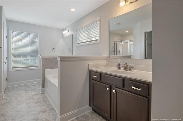 full bathroom featuring a garden tub, vanity, a shower stall, and a wealth of natural light