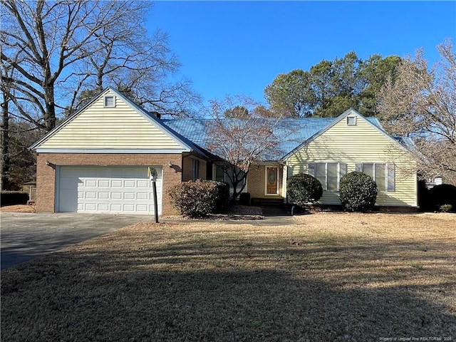 single story home featuring an attached garage, a front lawn, concrete driveway, and brick siding