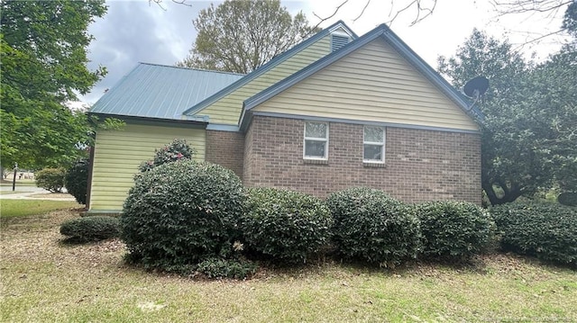 107 Oakmont Dr, Clinton, NC 28328 - view of home's exterior with brick siding, metal roof, and a lawn