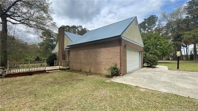 107 Oakmont Dr, Clinton, NC 28328 - view of side of home featuring metal roof, an attached garage, brick siding, driveway, and a yard