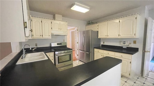 107 Oakmont Dr, Clinton, NC 28328 - kitchen featuring a sink, light floors, appliances with stainless steel finishes, under cabinet range hood, and dark countertops