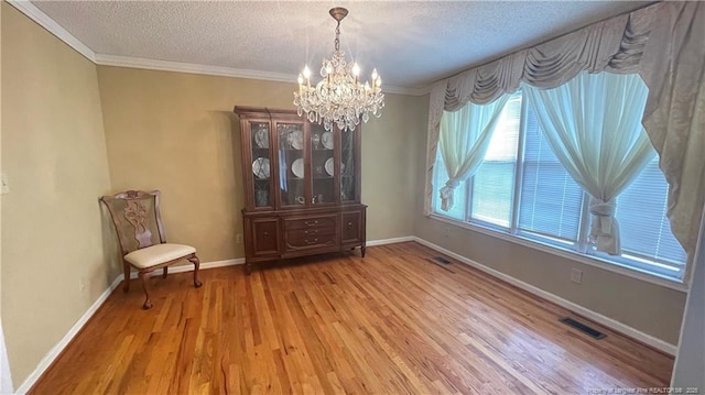 107 Oakmont Dr, Clinton, NC 28328 - unfurnished room with a textured ceiling, visible vents, a chandelier, and light wood-style floors