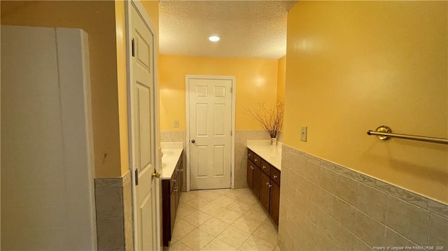 107 Oakmont Dr, Clinton, NC 28328 - bathroom featuring tile walls, a wainscoted wall, a textured ceiling, vanity, and tile patterned flooring