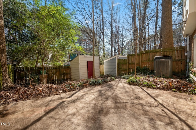 view of patio / terrace featuring cooling unit, fence, an outbuilding, and a storage unit