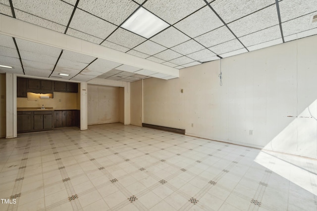 unfurnished living room featuring light floors and a drop ceiling