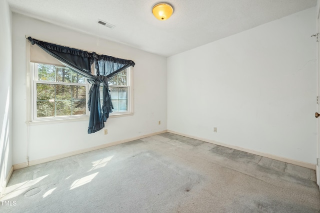 empty room featuring baseboards, visible vents, and carpet flooring