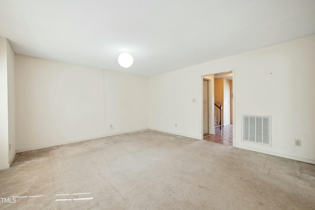 carpeted spare room featuring visible vents