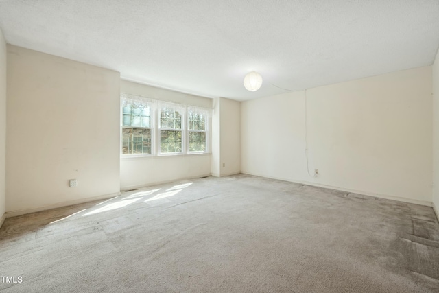 carpeted spare room with a textured ceiling