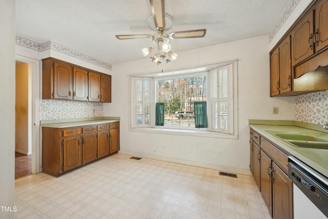 kitchen with light floors, white dishwasher, visible vents, and a sink