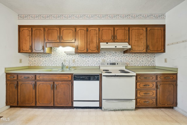 kitchen featuring white appliances, light floors, light countertops, under cabinet range hood, and a sink