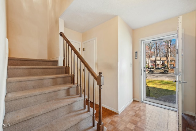 entryway featuring stairs and baseboards