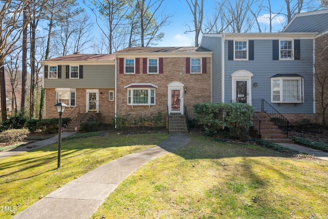 view of front of house with a front yard and brick siding