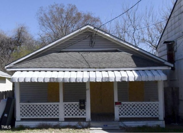 exterior space with covered porch and roof with shingles