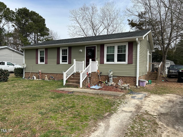 view of front of house with dirt driveway and a front lawn