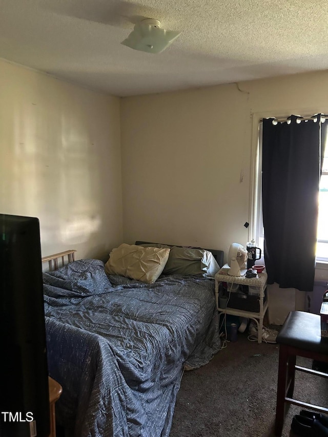 bedroom with a textured ceiling and carpet