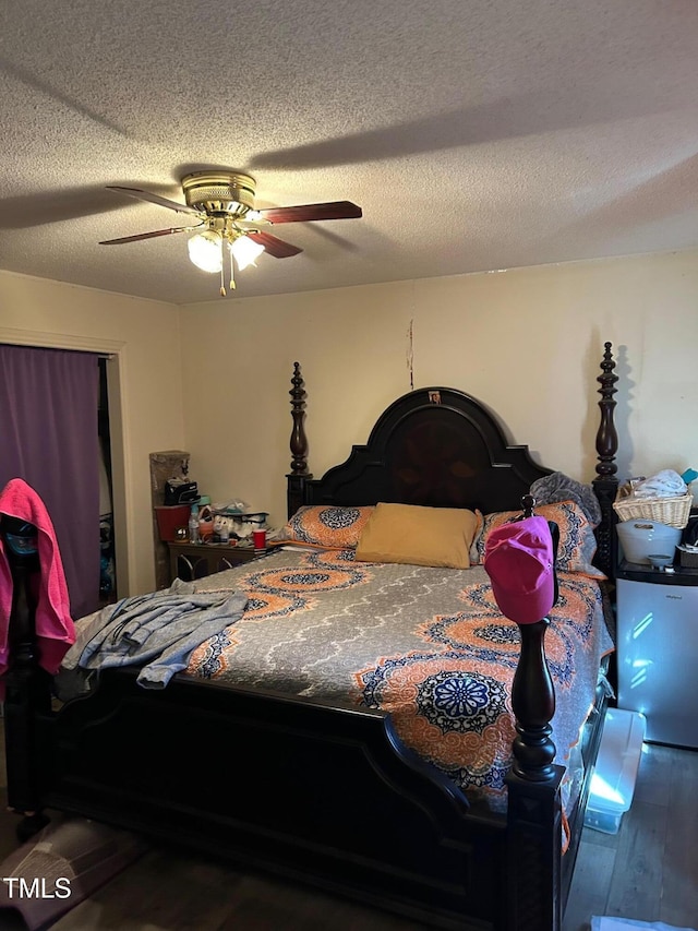 bedroom featuring wood-type flooring, a ceiling fan, and a textured ceiling