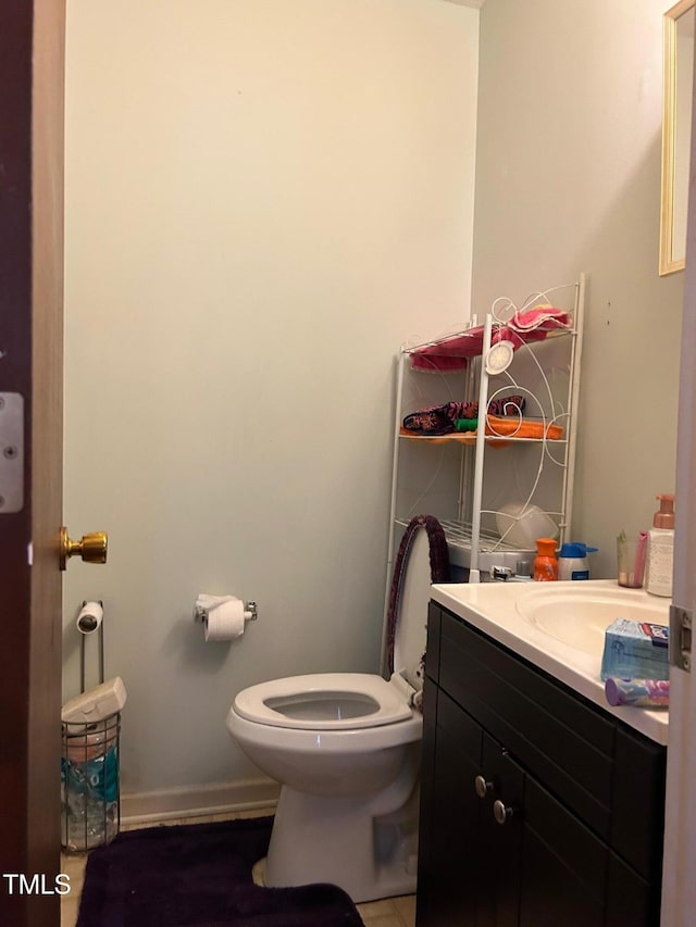 bathroom with baseboards, vanity, and toilet