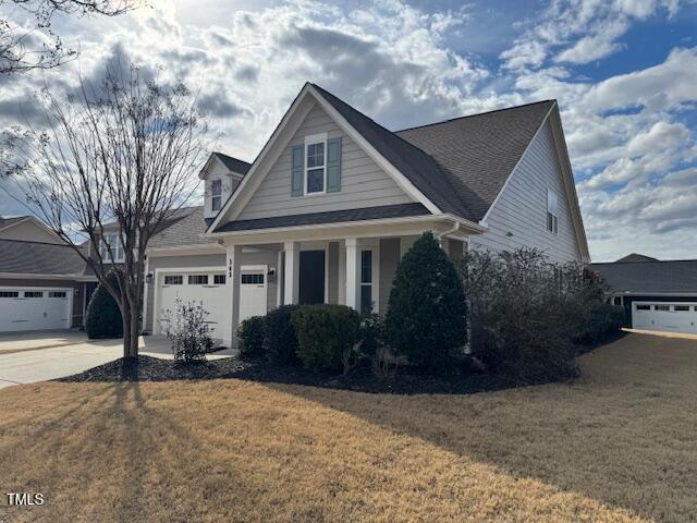 view of front of home with a garage, concrete driveway, and a front lawn