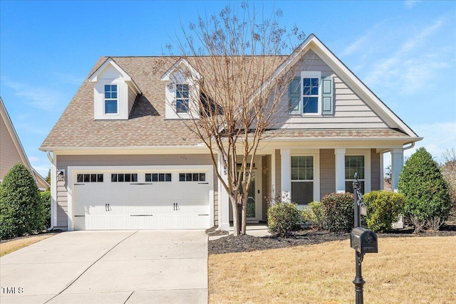 view of front facade featuring a front yard, covered porch, a shingled roof, concrete driveway, and a garage