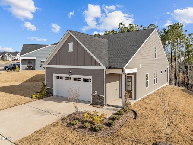 view of front of home with roof with shingles, concrete driveway, a garage, stone siding, and board and batten siding