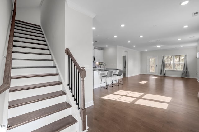 stairway with wood finished floors, recessed lighting, and baseboards