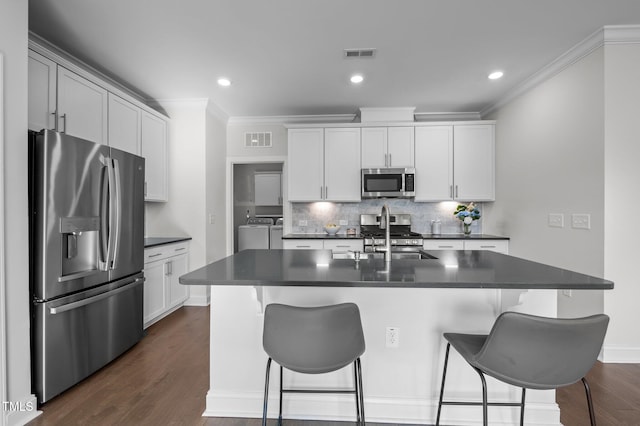 kitchen featuring dark countertops, stainless steel appliances, separate washer and dryer, and visible vents