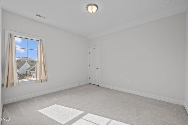 spare room with carpet flooring, baseboards, and visible vents