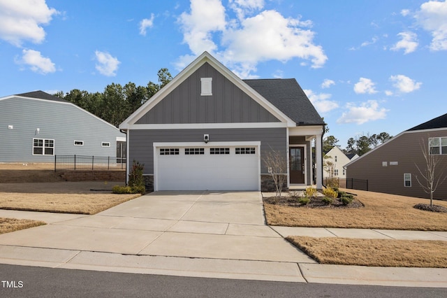 craftsman house with board and batten siding, concrete driveway, an attached garage, and fence