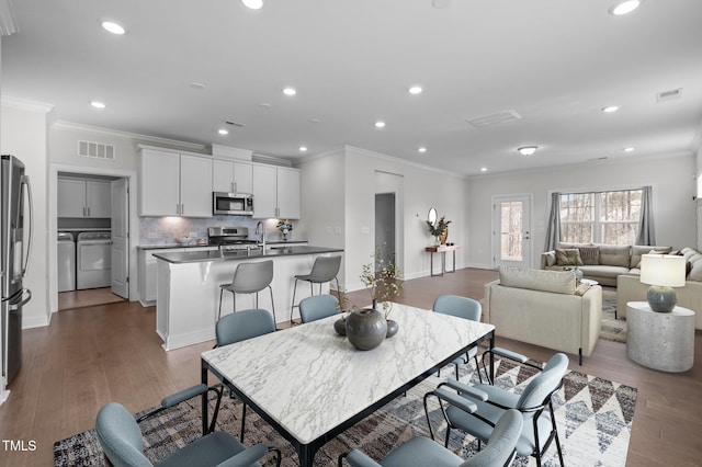 dining room featuring wood finished floors, separate washer and dryer, and visible vents