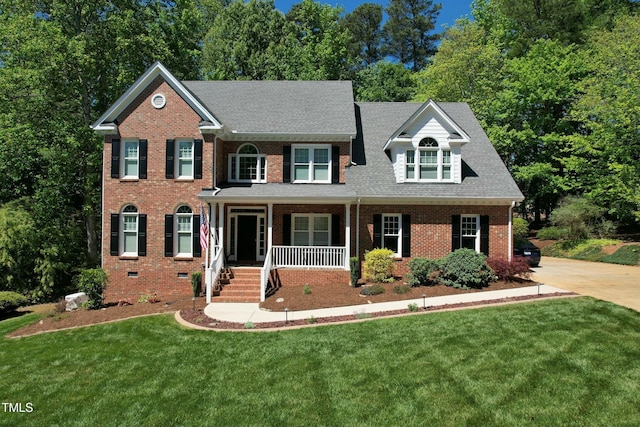 view of front of house with a porch, brick siding, roof with shingles, crawl space, and a front yard