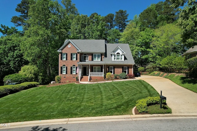 colonial inspired home featuring concrete driveway, crawl space, covered porch, a front lawn, and brick siding