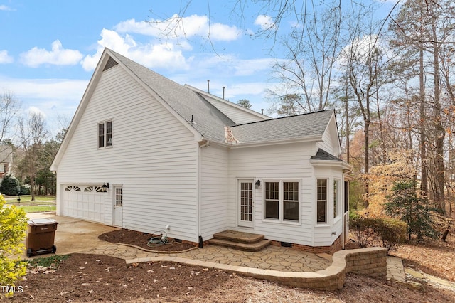 view of side of property featuring entry steps, a garage, a shingled roof, concrete driveway, and crawl space