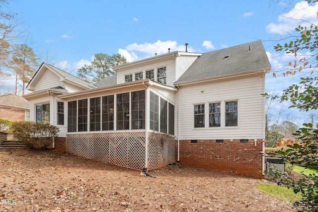 rear view of house with a sunroom and roof with shingles