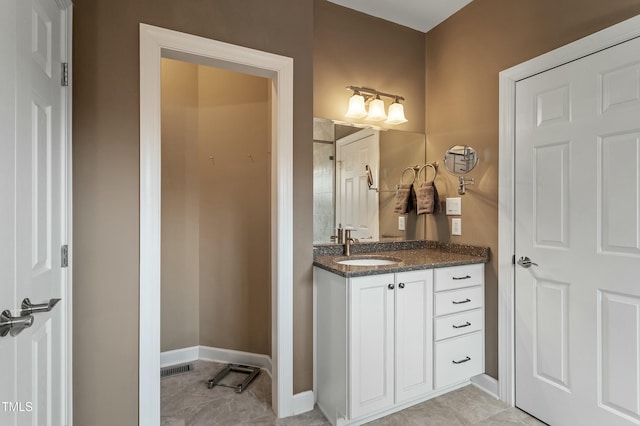 bathroom featuring visible vents, vanity, and baseboards